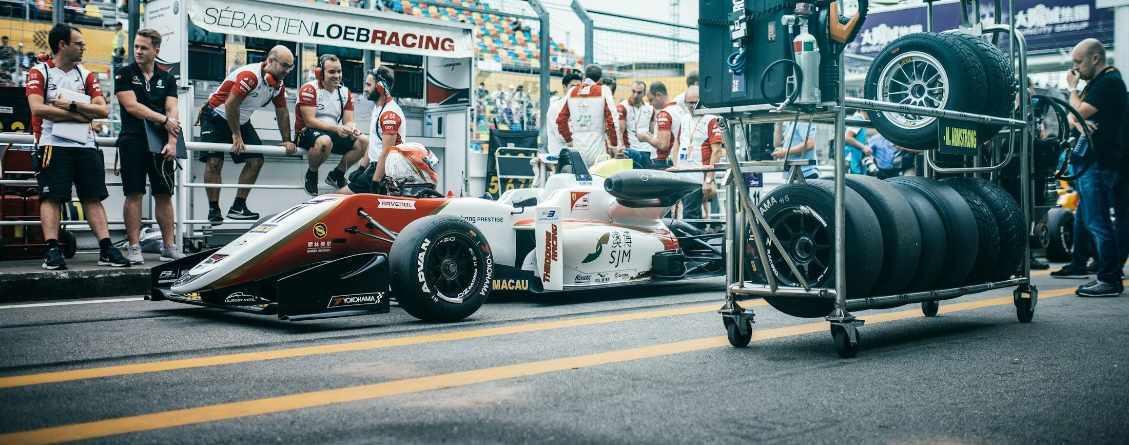 A race team pit crew ready together beside the car